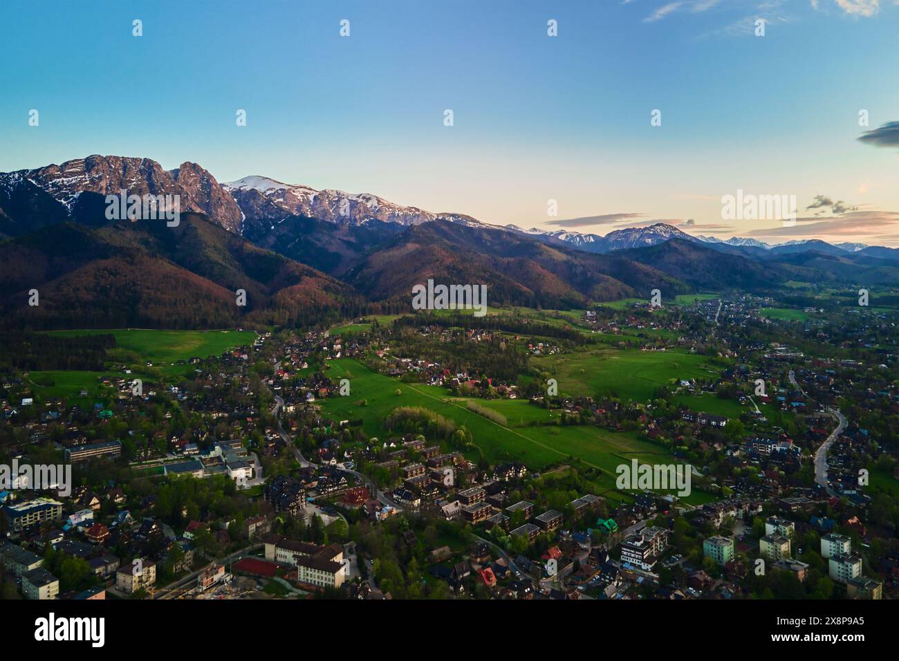Aus der Vogelperspektive auf Tatra und Zakopane bei Sonnenuntergang. Panoramablick mit Bergketten und grünen Tälern in der Nähe des Dorfes. Blick auf Giewont, Stockfoto