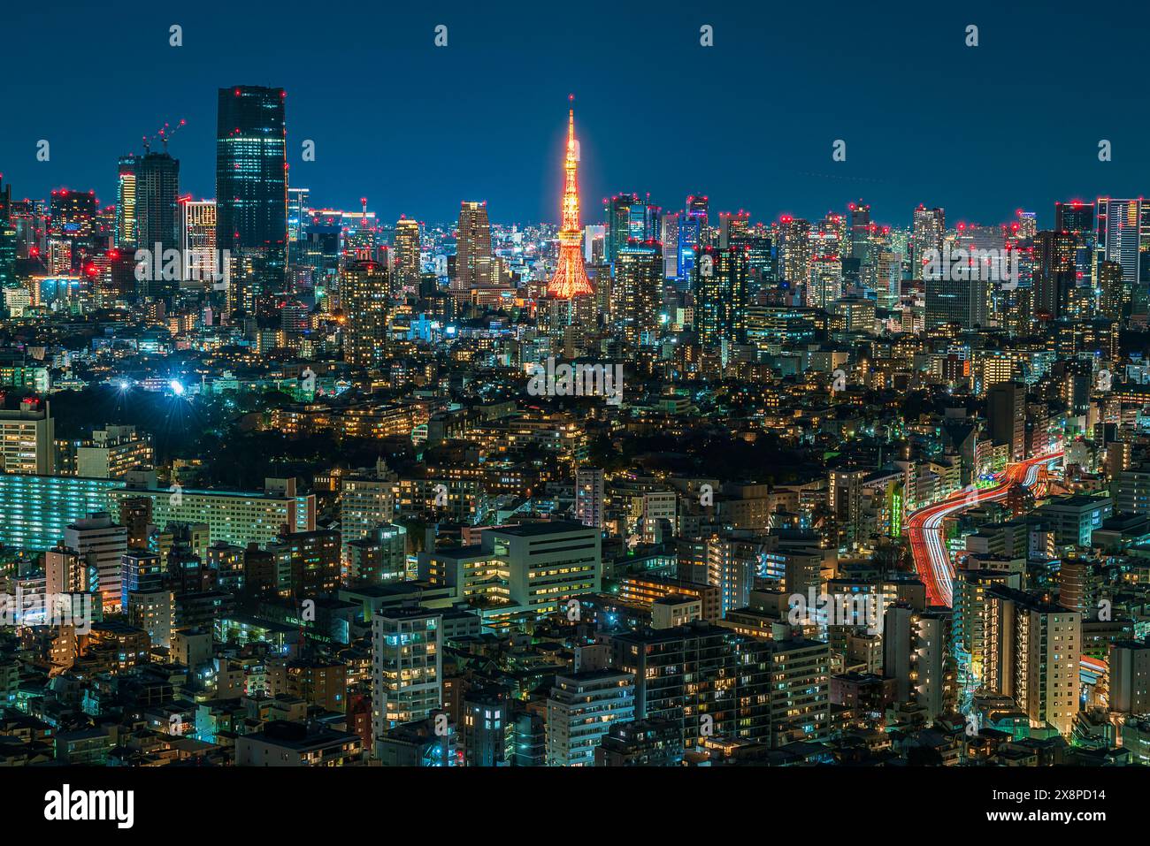 Der Tokyo Tower beleuchtet das Stadtbild, dessen Stahlrahmen sich von der glitzernden Skyline Tokios abhebt Stockfoto