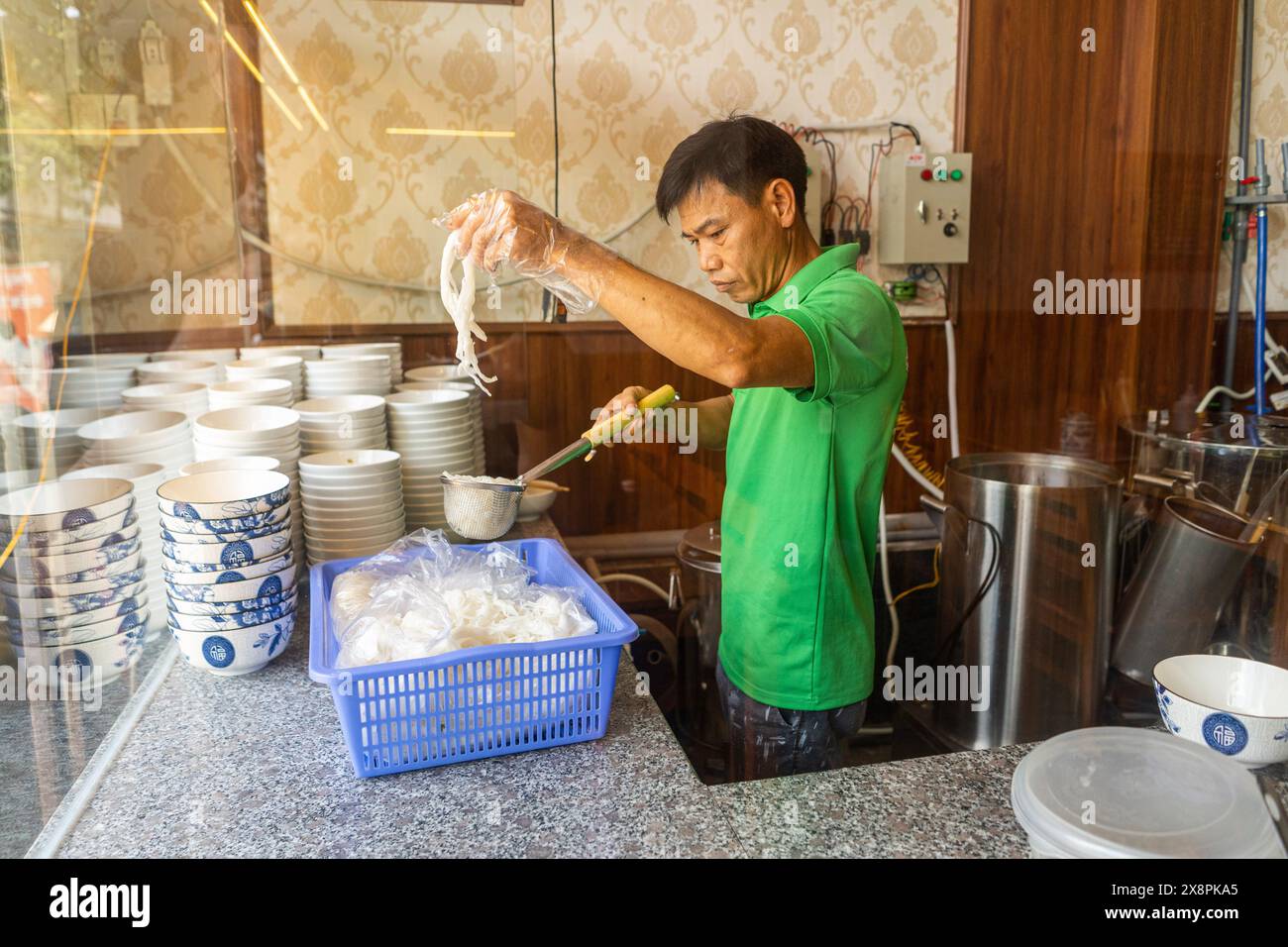 Ein Mann, der traditionelle Hühnernudeln Pho Suppe zubereitet Stockfoto