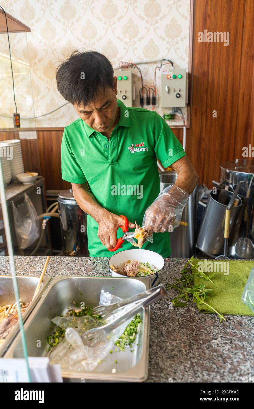 Ein Mann, der traditionelle Hühnernudeln Pho Suppe zubereitet Stockfoto