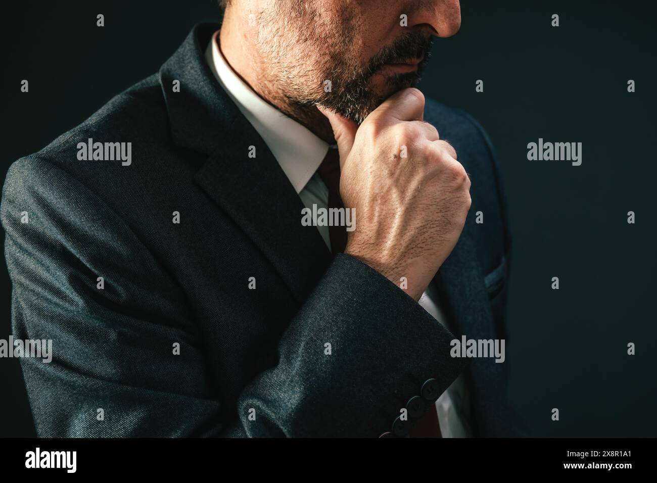 Nahaufnahme-Porträt eines männlichen kaukasischen Politikers, der denkt und das Kinn streichelt, selektiver Fokus Stockfoto