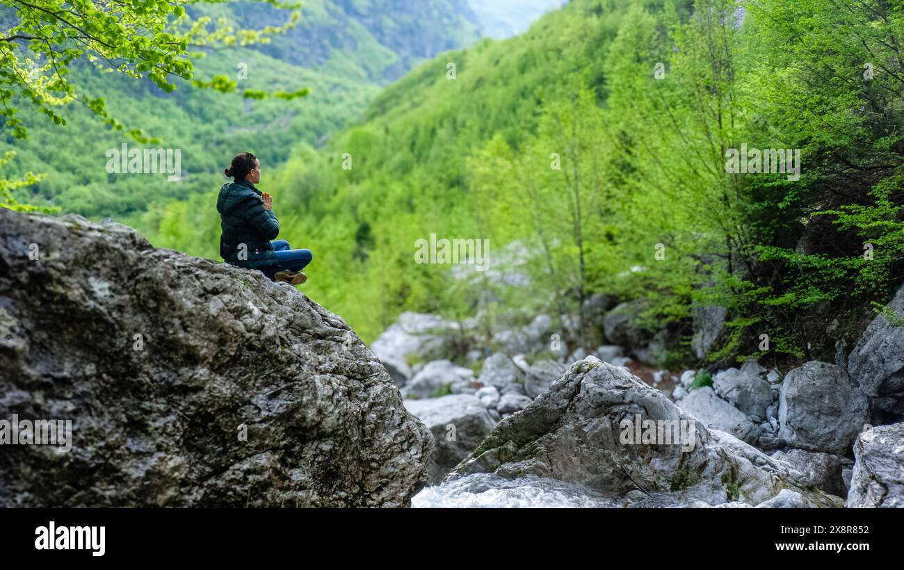 Frau saß in tiefer Meditation mitten im Wald im Hochgebirge Theth Albanien Stockfoto