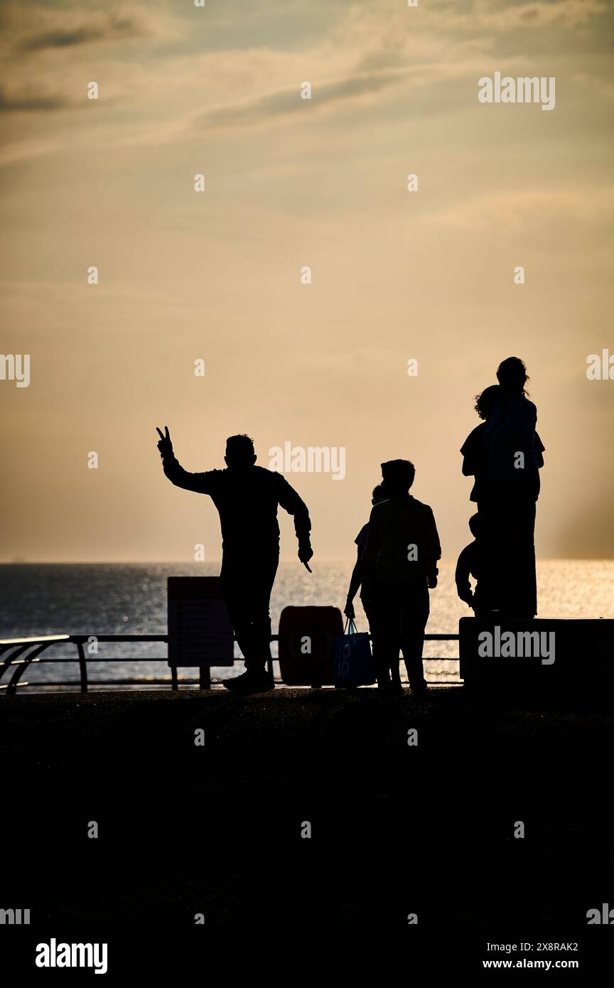 Familienurlaub in Silhouette an der Küste von Blackpool bei Sonnenuntergang Stockfoto
