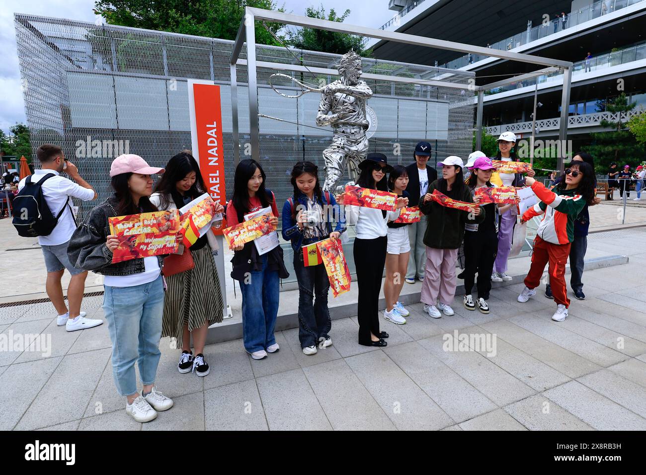 Fans of Spain's Rafael Nadal pose for pictures with his statue ahead of his first round match of the French Open tennis tournament against Germany's Alexander Zverev at the Roland Garros stadium in Paris, Monday, May 27, 2024. (AP Photo/Aurelien Morissard) Stockfoto