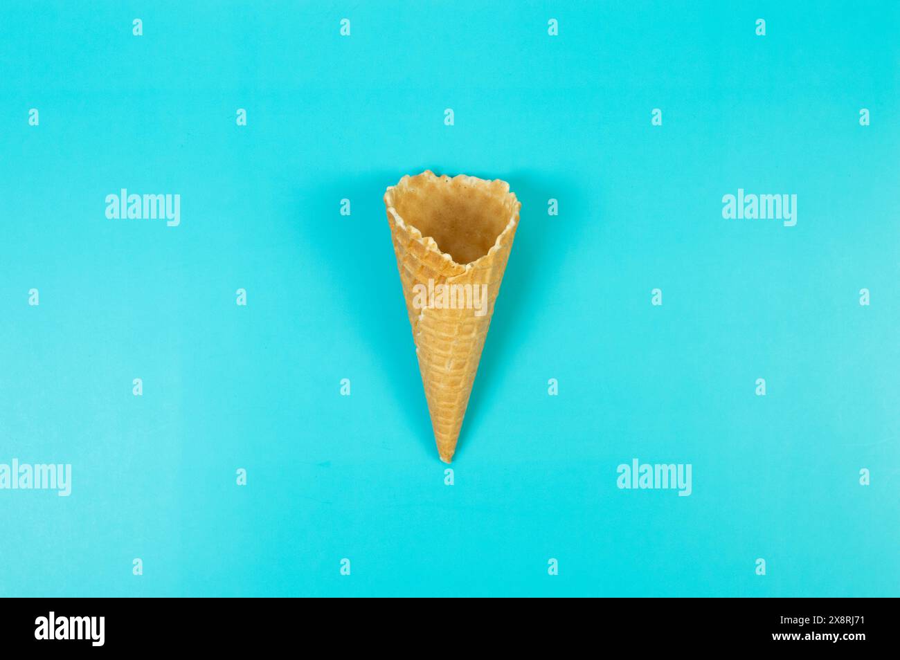 Blick von oben auf Eiswaffelkegel auf blauem Hintergrund. Sommertapete, flach, Kopierraum. Stockfoto