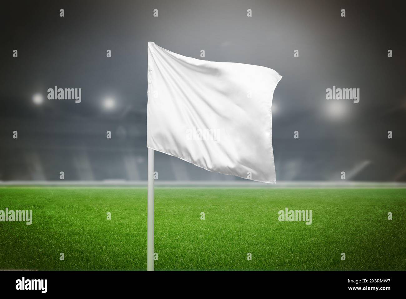 Weiße Eckfahne in einem Fußballstadion mit leerem Platz, ideal für Logo- oder Markenwerbung, die das Sportmarketing unterstreicht Stockfoto