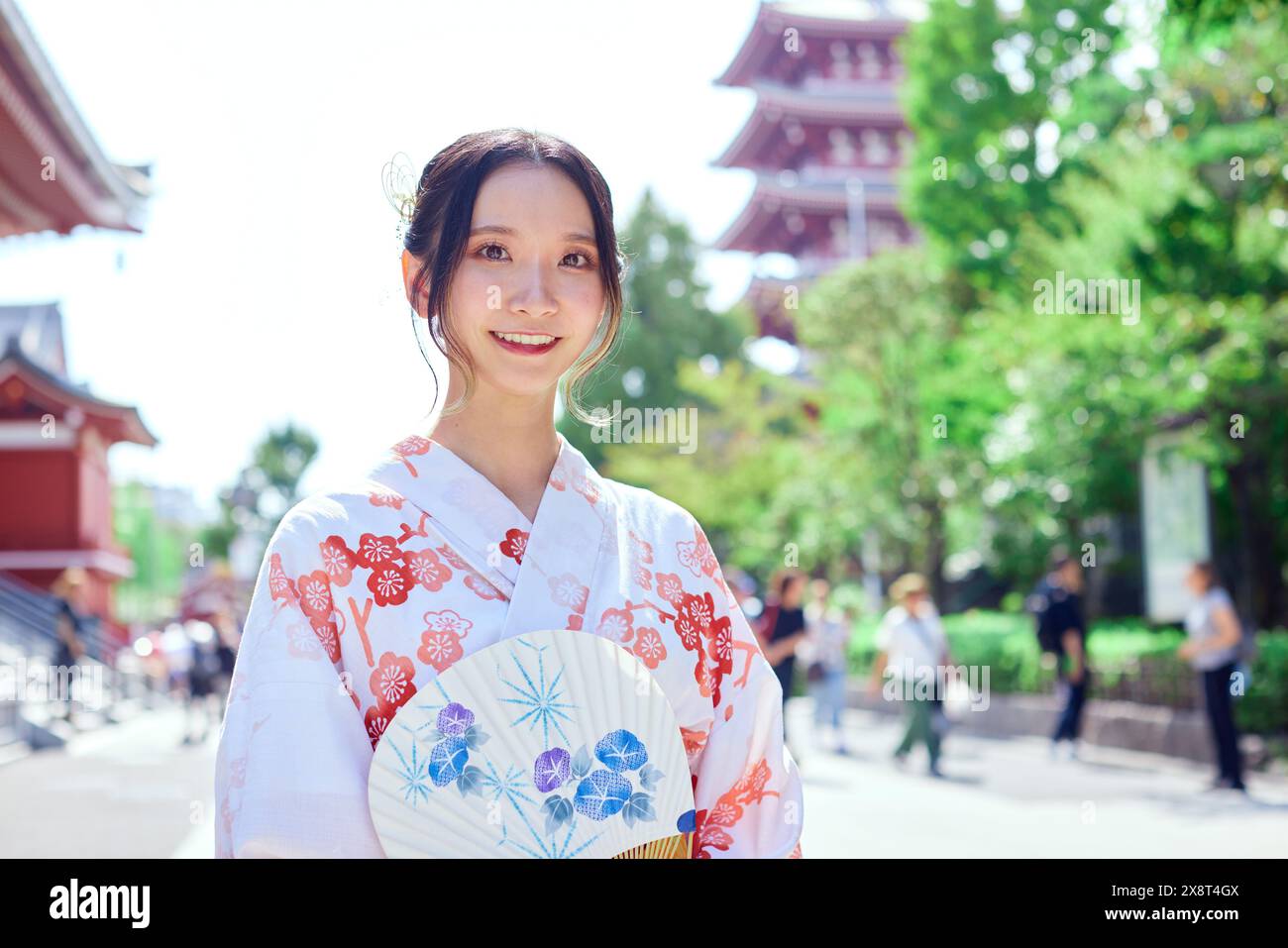 Japanische Frau in einem Yukata, die den traditionellen Tempel in Tokio besucht Stockfoto