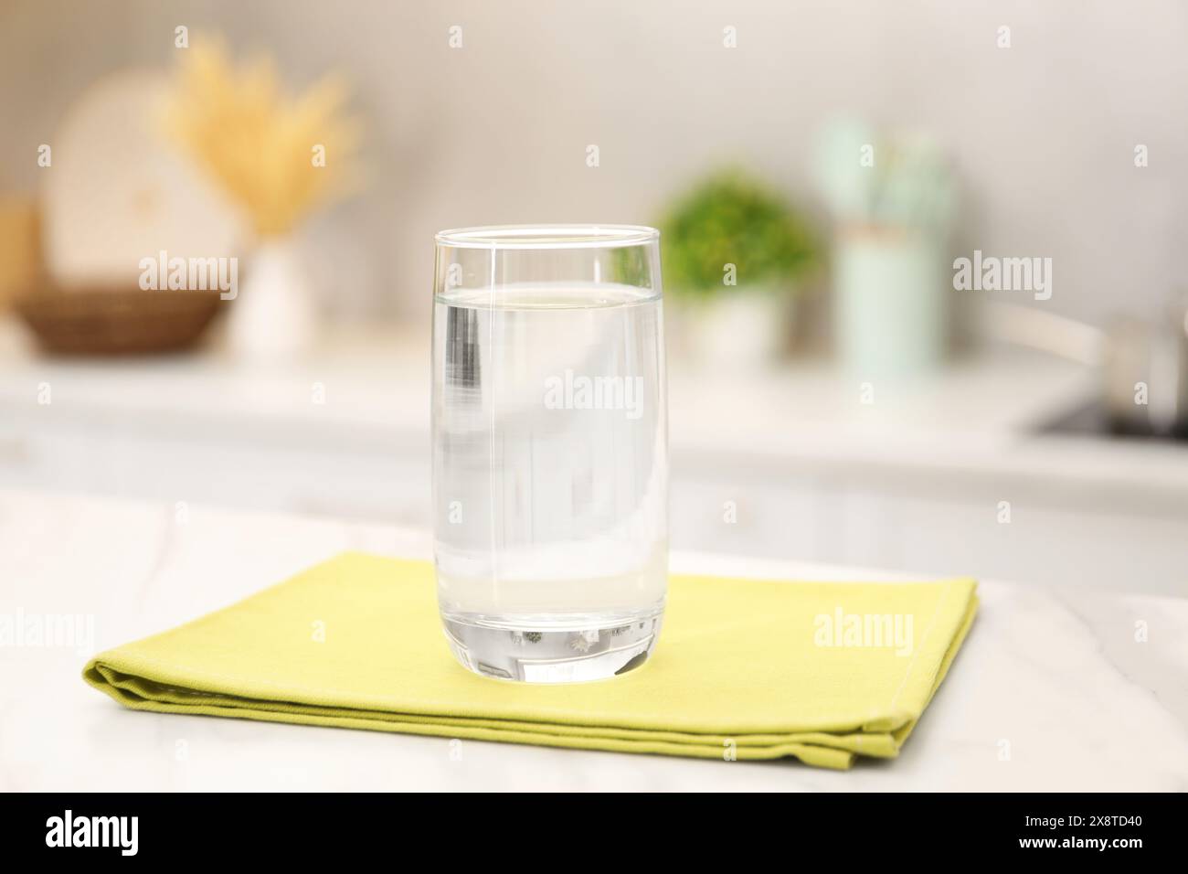 Glas mit klarem Wasser auf weißem Marmortisch in der Küche Stockfoto