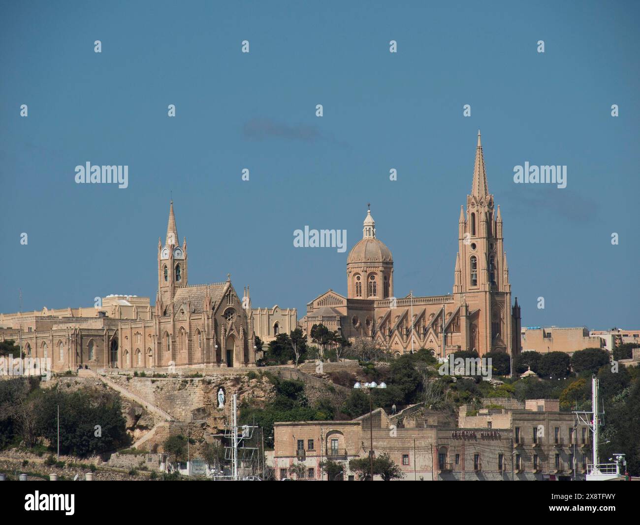Historischer Kirchenkomplex mit verschiedenen Türmen und einer Kuppel, umgeben von alten Gebäuden und Bäumen unter klarem Himmel, historische Kirche auf einem Hügel neben dem Stockfoto
