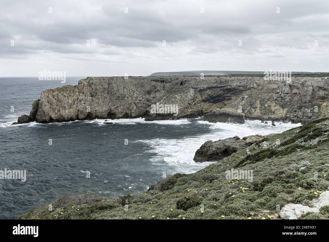 Malerischer Blick auf die zerklüfteten Klippen und den Atlantischen Ozean im Cabo San Vicente, Portugal. Die einzigartigen Felsformationen und die nebelige Atmosphäre schaffen einen Dramat Stockfoto