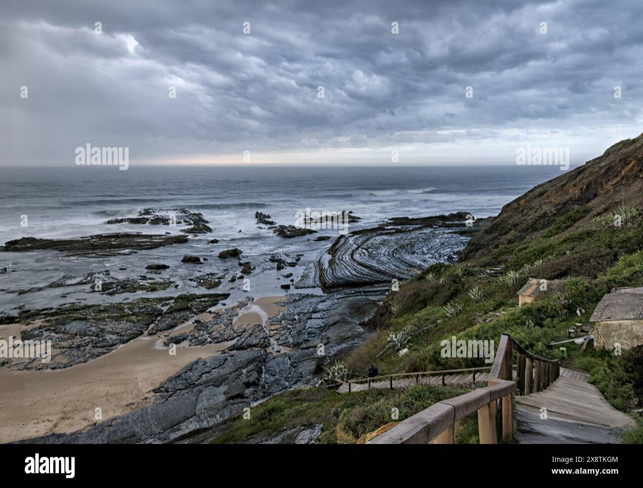 Ein ruhiger Blick auf den Strand Carriagem in Portugal bei Sonnenuntergang, mit sanften Wellen, die gegen das Ufer plätschern. Stockfoto