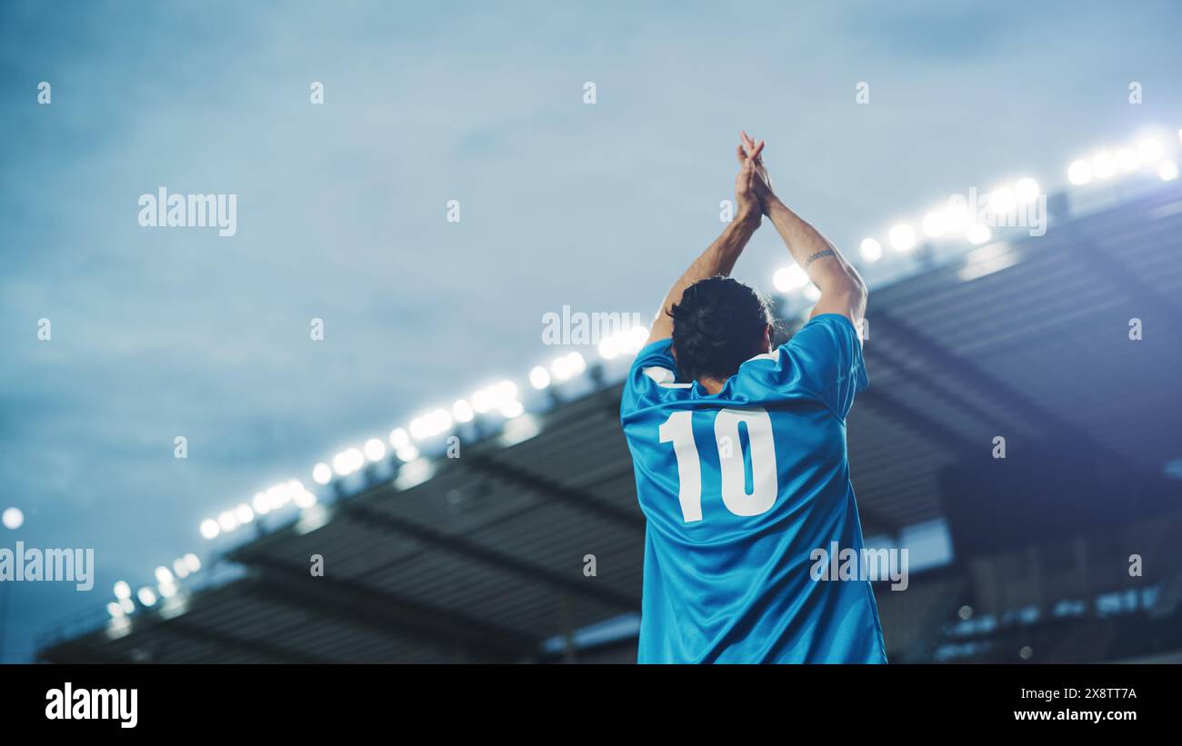 Football Match Championship: Porträt des Fußballspielers, der steht, posiert, lächelt, die Hände zum Anfeuern hebt. Professioneller hispanischer Fußballspieler, Champion Ready to Win Cup, Turnier. Mittlere Rückaufnahme Stockfoto