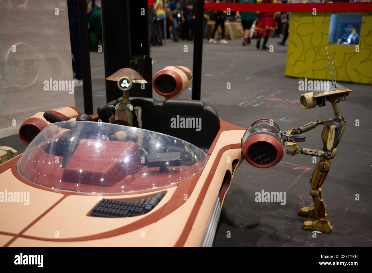 Ein Modell von zwei kleinen Droiden, die einen Speeder auf der Comic Con London reparieren Stockfoto