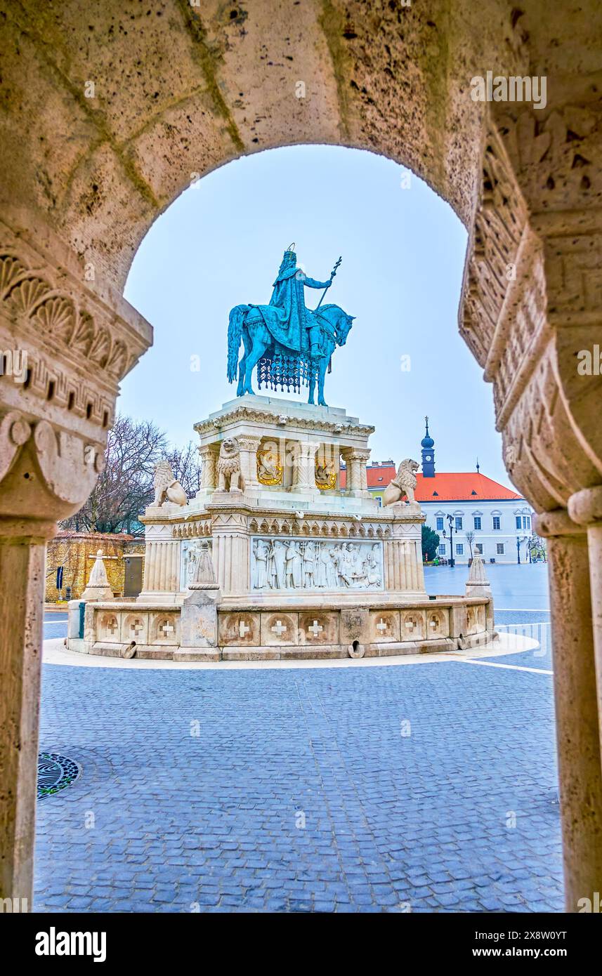 Der Blick auf die St. Stephan Statue auf dem Heiligen Dreifaltigkeitsplatz durch den Bogen der Steingalerie der Fischerbastei, Budapset, Ungarn Stockfoto