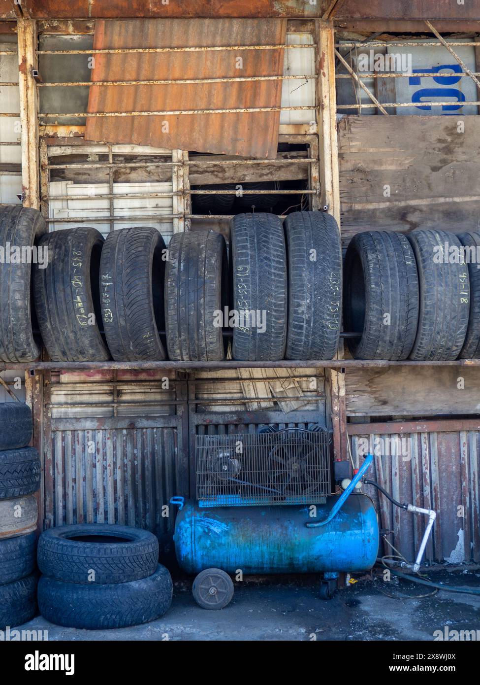 Alte Reifenwerkstatt. Viele Reifen von Pkw. Privatunternehmen. Hilfe für Autobesitzer Stockfoto