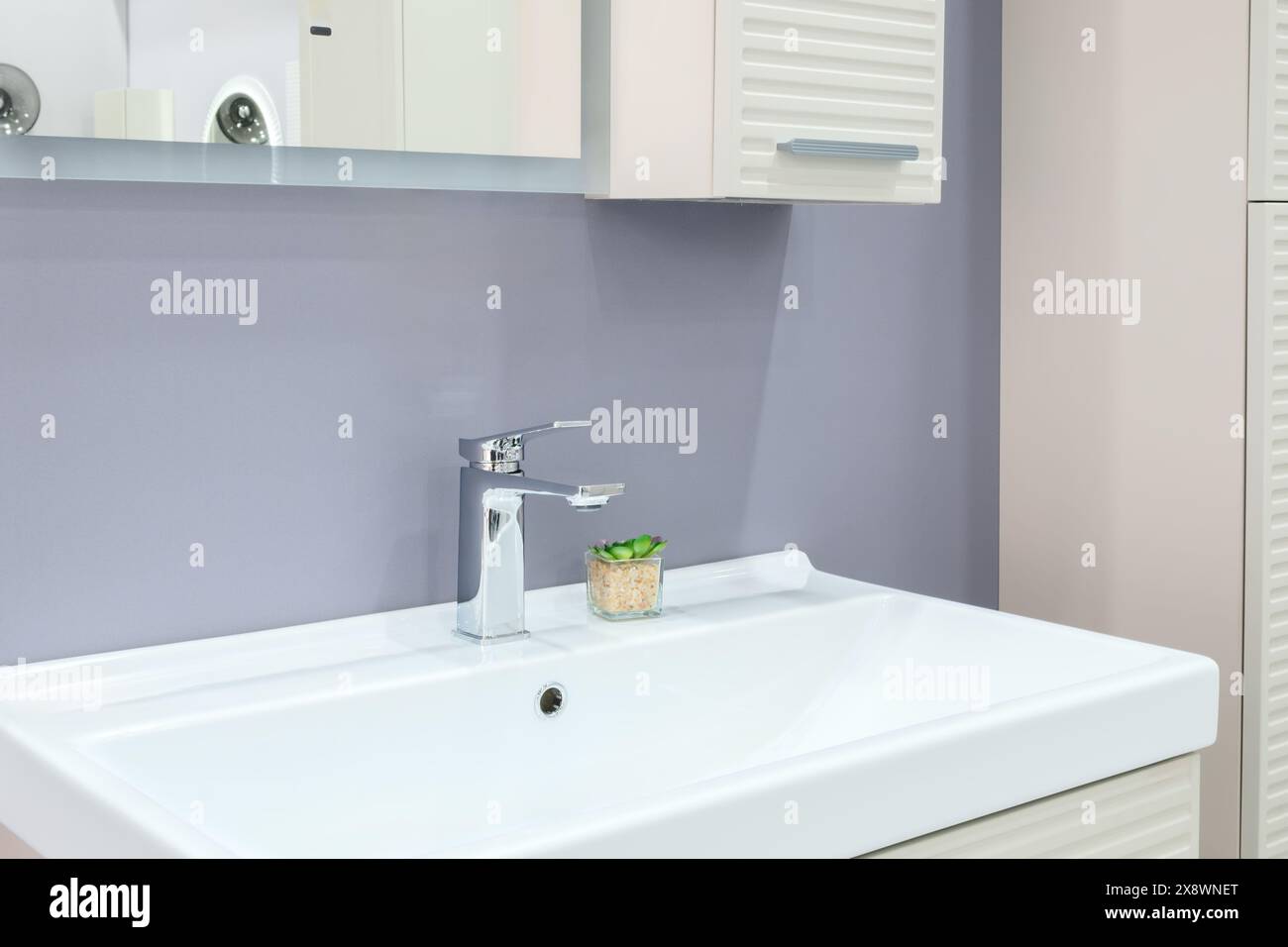 Ein Waschbecken im Badezimmer mit Wasserhahn und einer weißen Ablagefläche Stockfoto