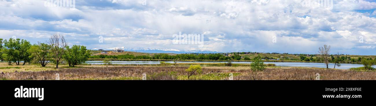 Colorado Living. Broomfield, Colorado - das Wohnpanorama im Metro-Gebiet von Denver mit einem Teich im Vordergrund und Blick auf eine Bergkette Stockfoto