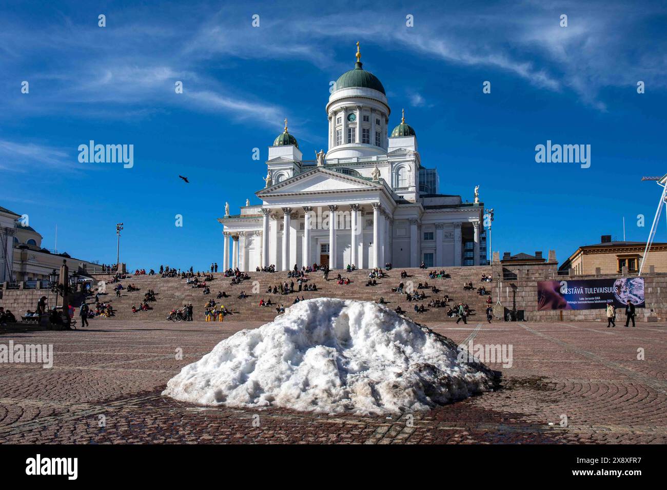 Schmelzender Schneehaufen auf dem Senatsplatz mit der Kathedrale von Helsinki im Hintergrund am 1. Mai im Bezirk Kruununhaka in Helsinki, Finnland Stockfoto