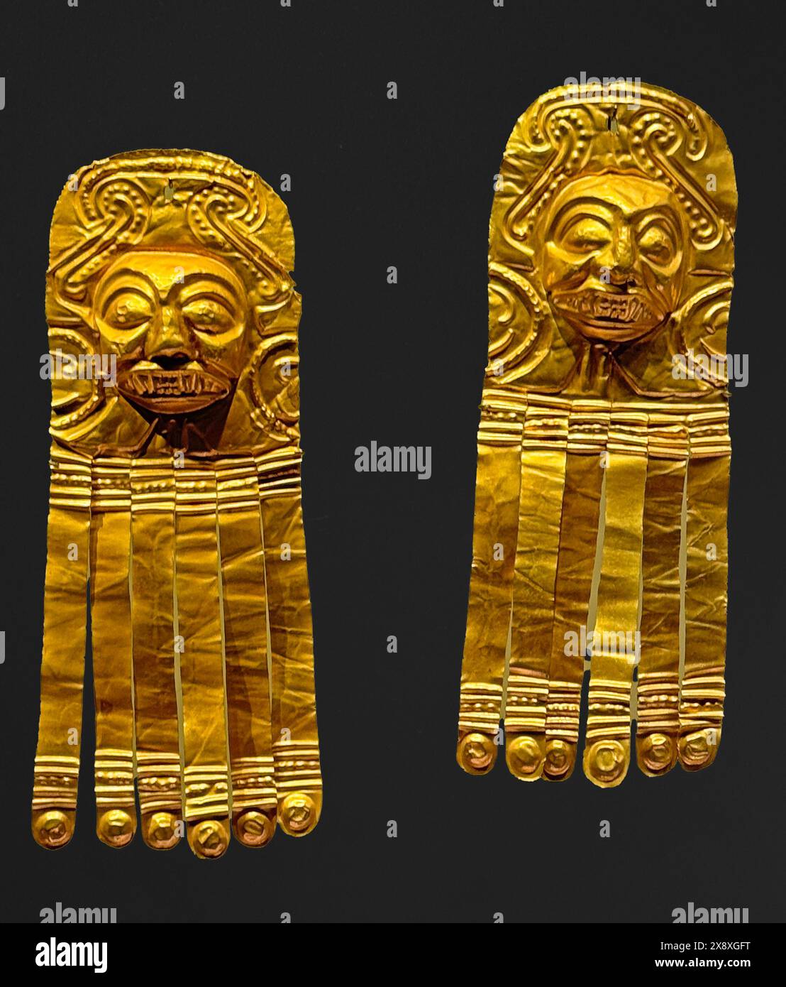 Antike präkolumbische Ohrringe aus Gold, die in archäologischen Stätten im Goldmuseum von Bogota gefunden wurden Stockfoto