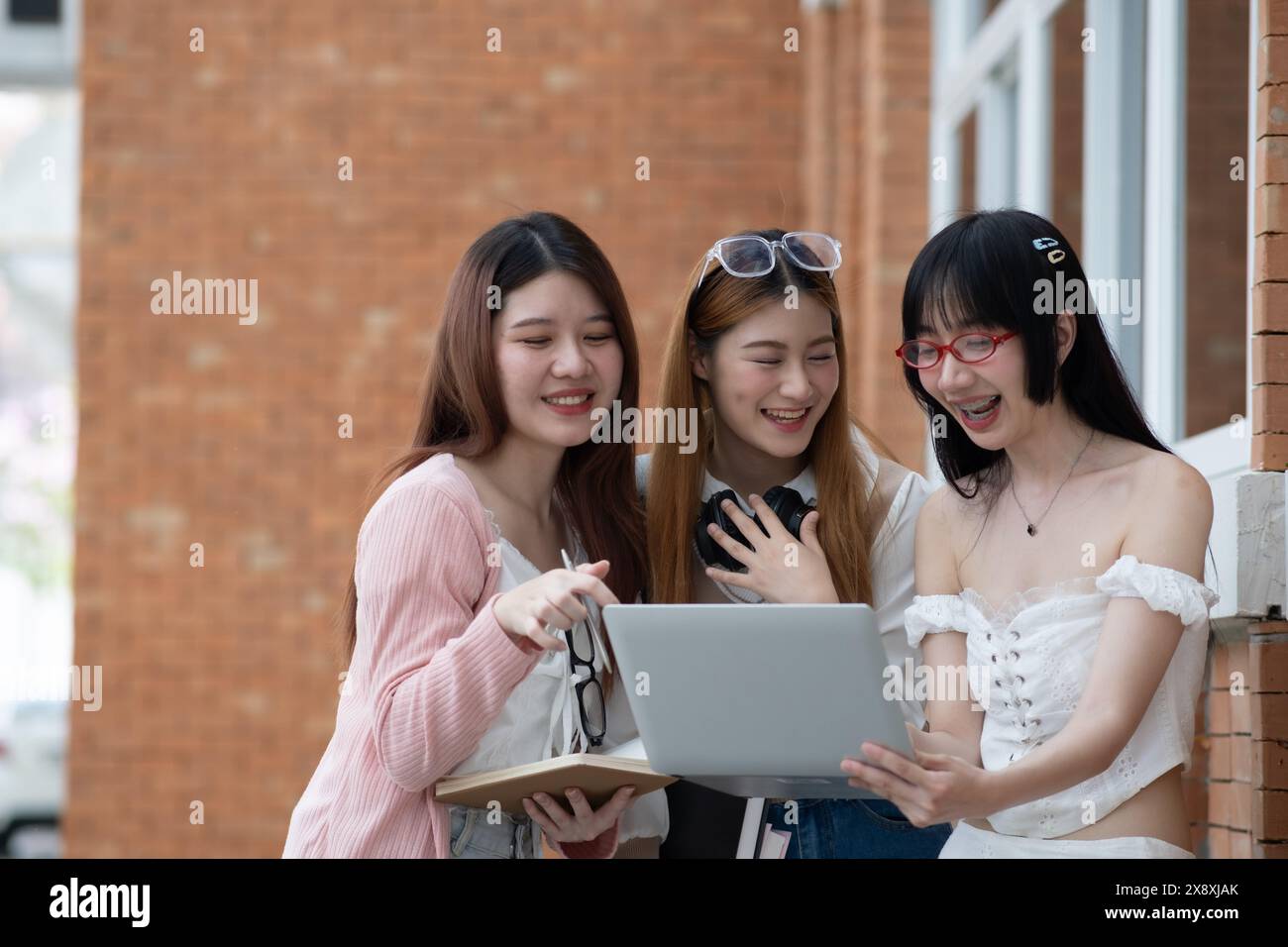 Gruppe junger Studenten, die Laptop-Smartphone für Hirnsturm-Präsentation, Hausaufgaben, Diskussionen, Planung für ein neues Projekt verwenden. Stockfoto