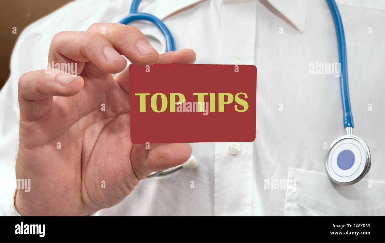 Geschäftskonzept. TEXTTIPPS auf einer Visitenkarte, eine Karte in der Hand eines Mannes in einem weißen Hemd mit einem Stethoskop um den Hals Stockfoto