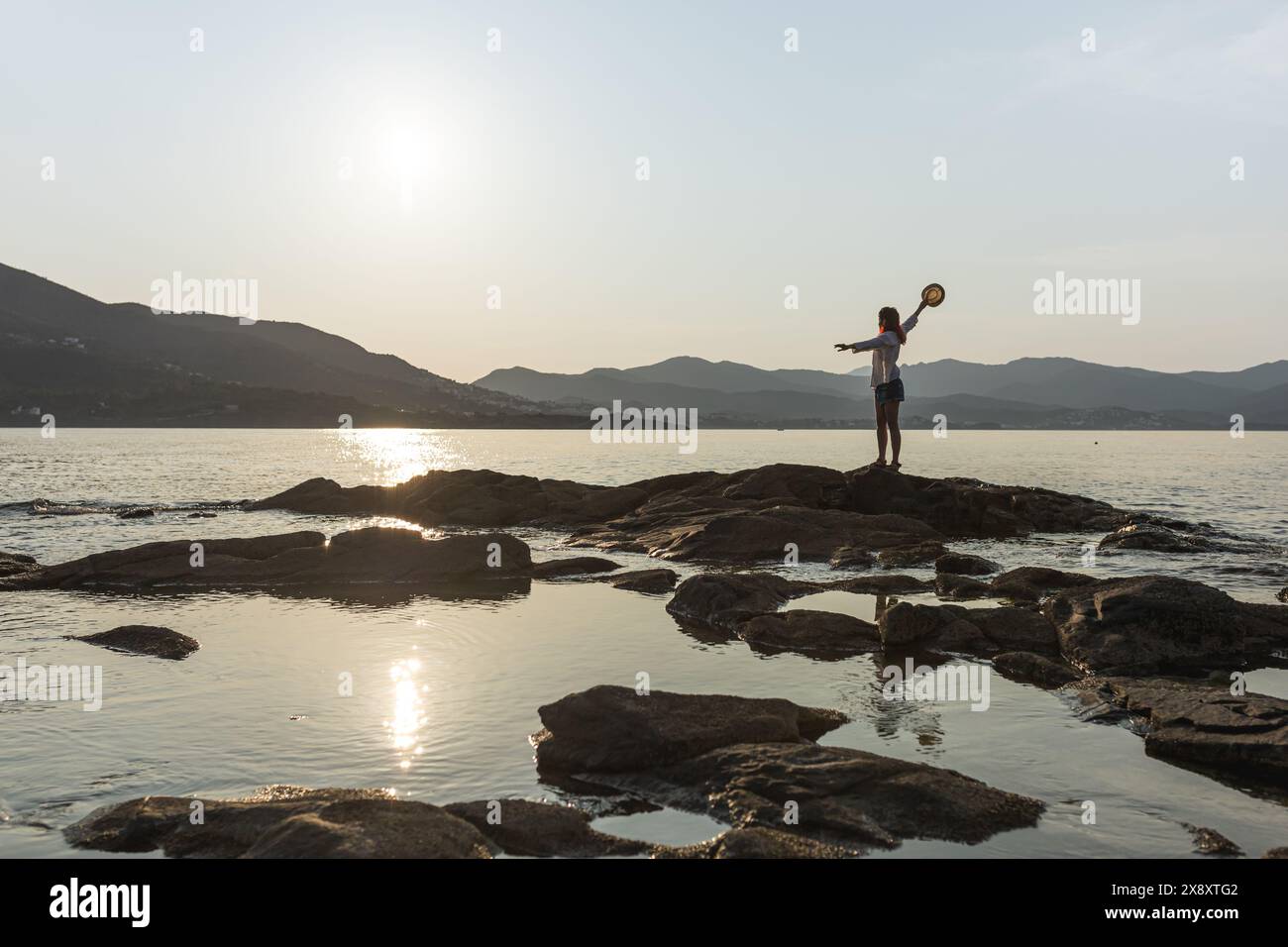 Frau, die zu Hause mit einem Tablet arbeitet schönes Fensterlicht gemütlich, lächelnd in die Kamera schaut, Kamera zeigt, Pflanzen Stockfoto