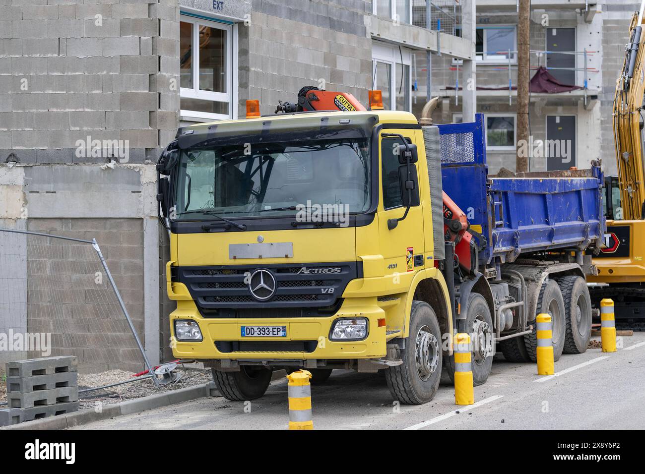 Nancy, Frankreich – Gelb-Blau-Muldenkipper Mercedes-Benz Actros 4151 auf einer Baustelle. Stockfoto