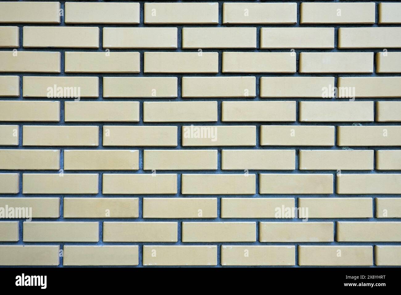 Wand aus glatten beigen Ziegeln als Nahaufnahme des Hintergrunds Stockfoto