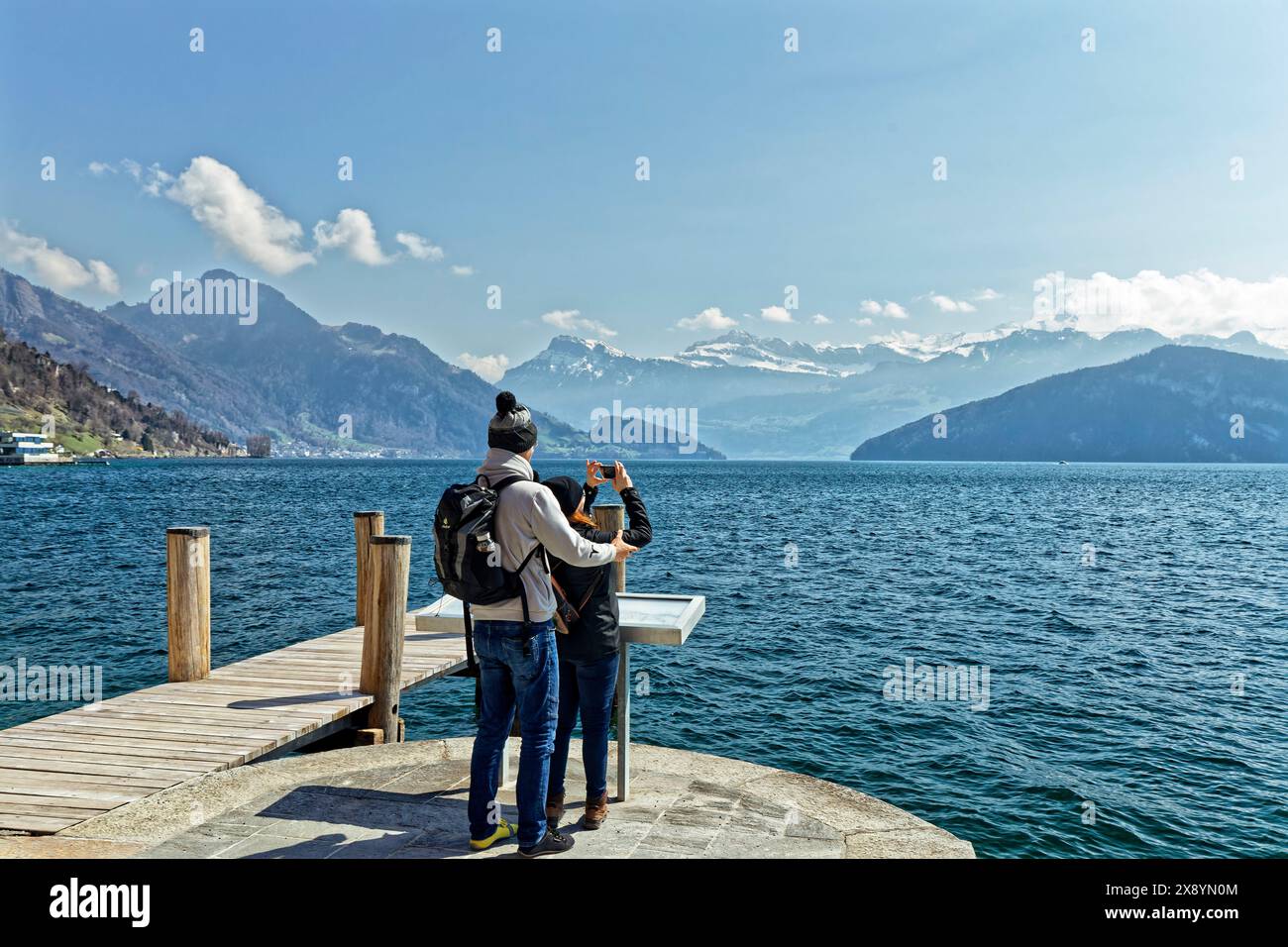 Schweiz, Kanton Luzern, Weggis, Vierwaldstättersee, Paar fotografiert den Vierwaldstättersee, im Hintergrund die Schweizer Alpen Stockfoto