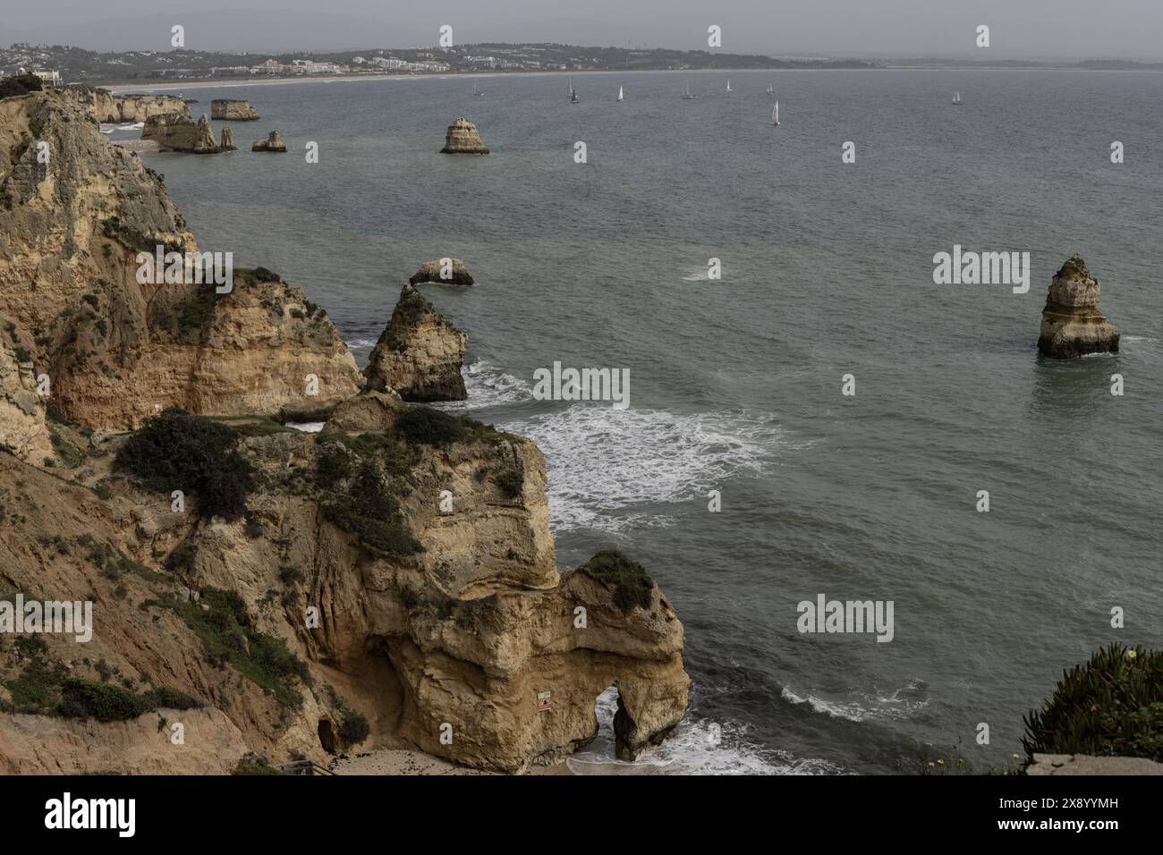 Malerischer Blick auf die felsigen Klippen und Meeresberge am Strand von Camilo in Portugal. Die zerklüftete Küste bietet dramatische Felsformationen und einen Sandstrand. Stockfoto
