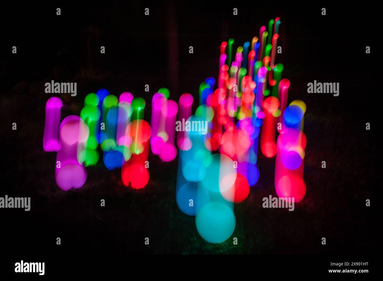 Helles Gemälde abstrakter Hintergrund. Bunte Lichtkugeln, lange Belichtung. Abstrakter Schmetterling auf schwarzem Hintergrund. Zoom Burst-Effekt. Stockfoto