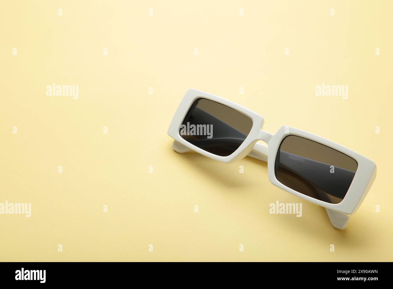 Weiße Sonnenbrille auf gelbem Hintergrund, Draufsicht, flache Lage, minimalistisches Konzept des Sommers, Urlaub. Stockfoto