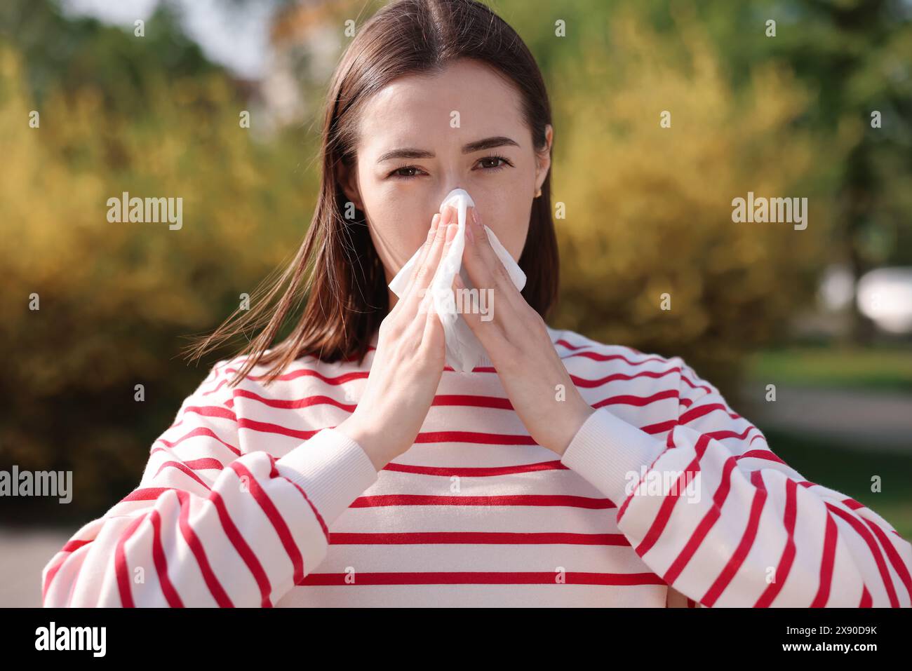 Frau mit Serviette, die draußen saisonale Allergie hat Stockfoto