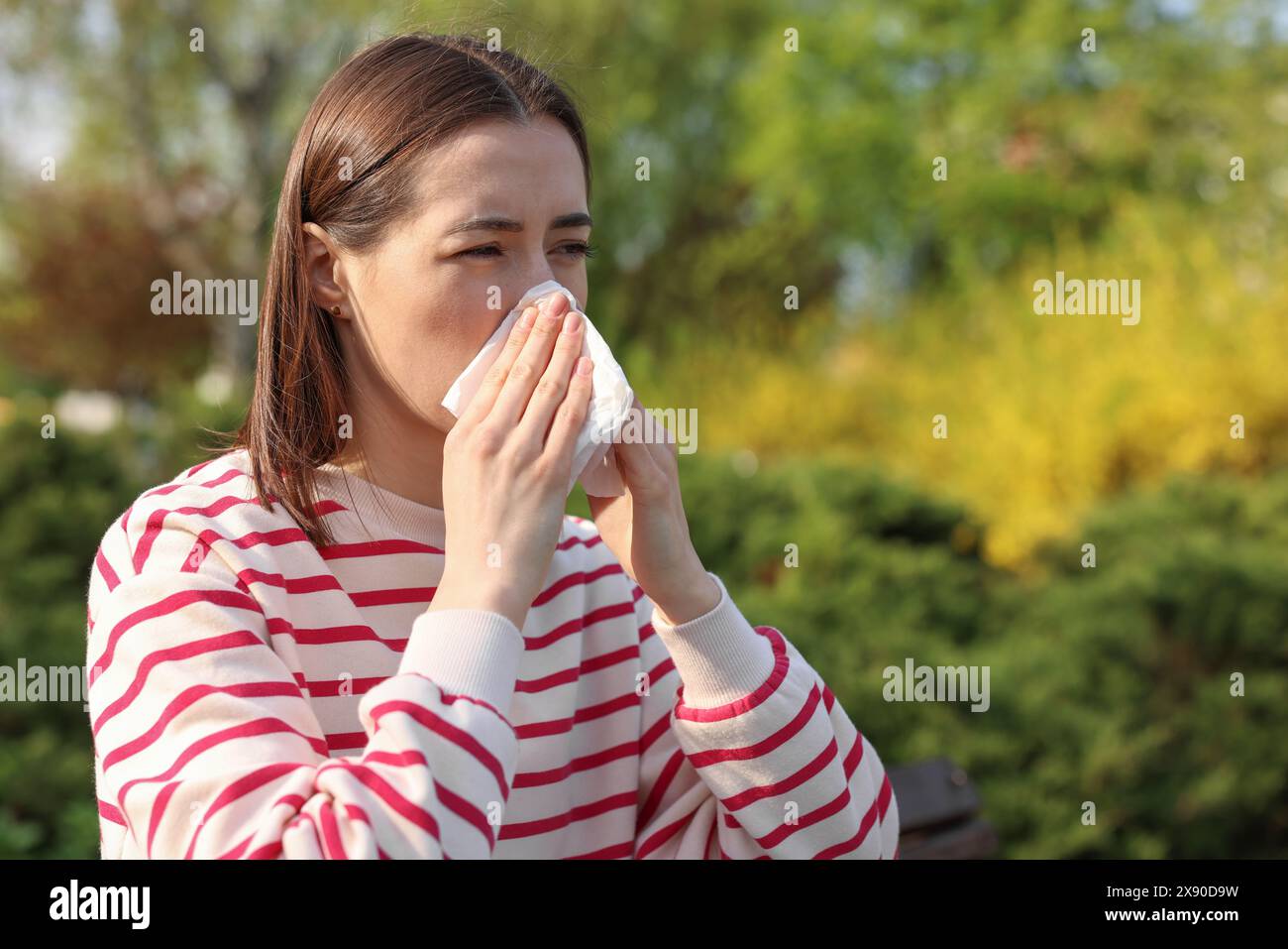 Frau mit Serviette, die draußen saisonale Allergie hat Stockfoto