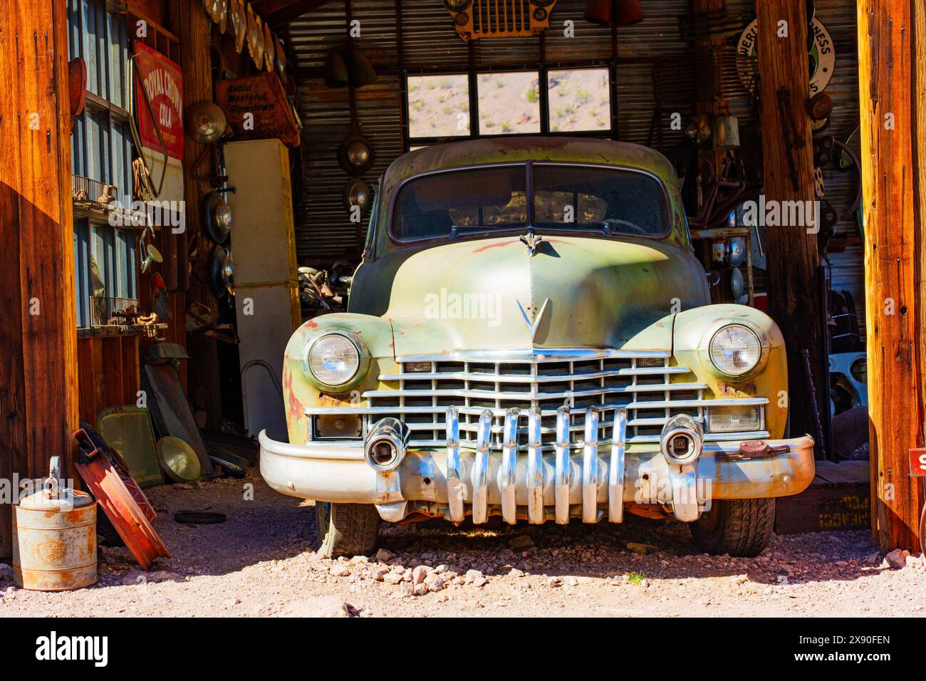 Nelson, Nevada - 15. April 2024: Verwitterter Oldtimer parkte in einer alten Garage an der alten Tankstelle der verlassenen Goldminensiedlung Stockfoto