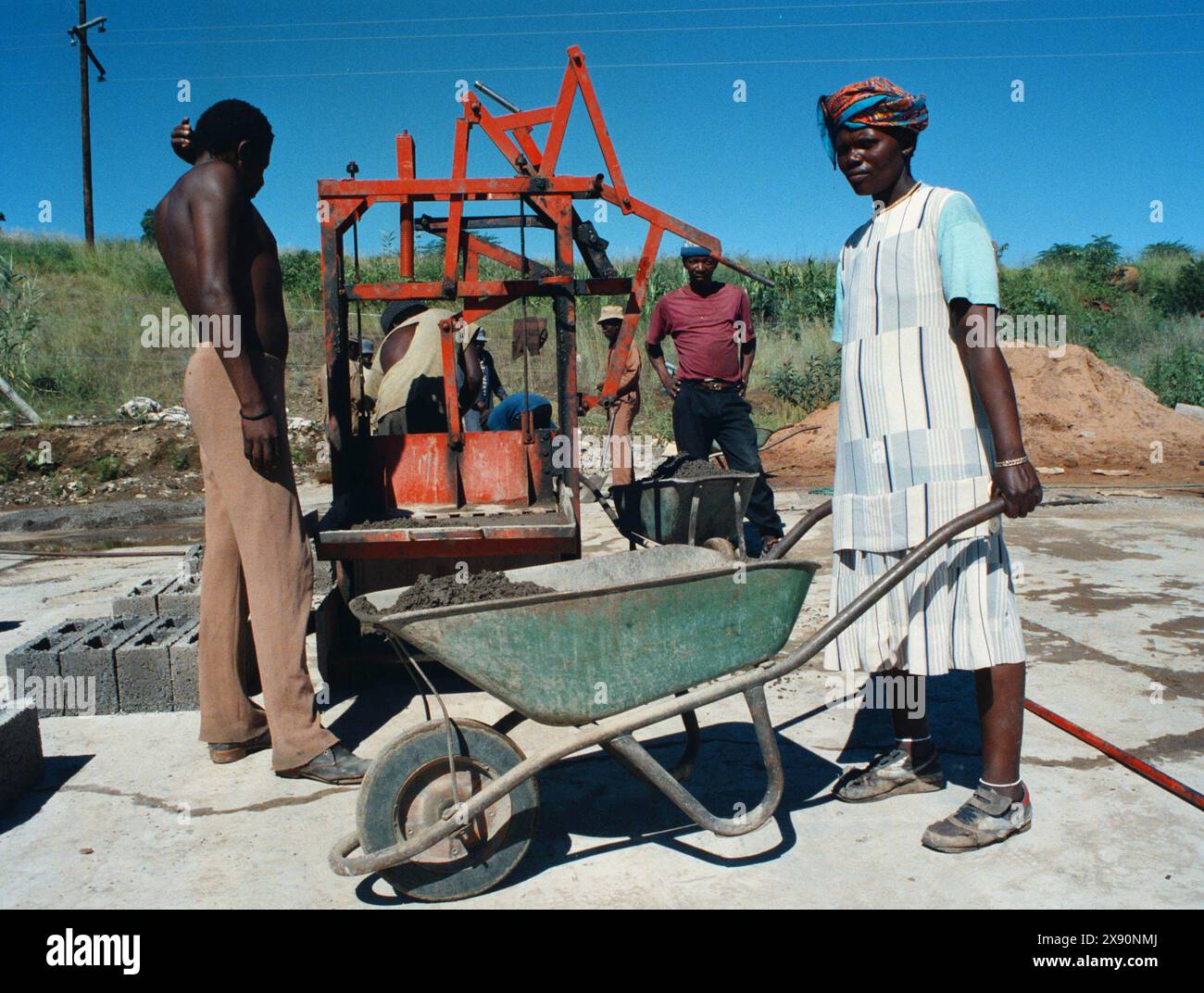 Anwohner, die Ziegelsteine für ein kommunales Wohnprojekt bauen. Stockfoto