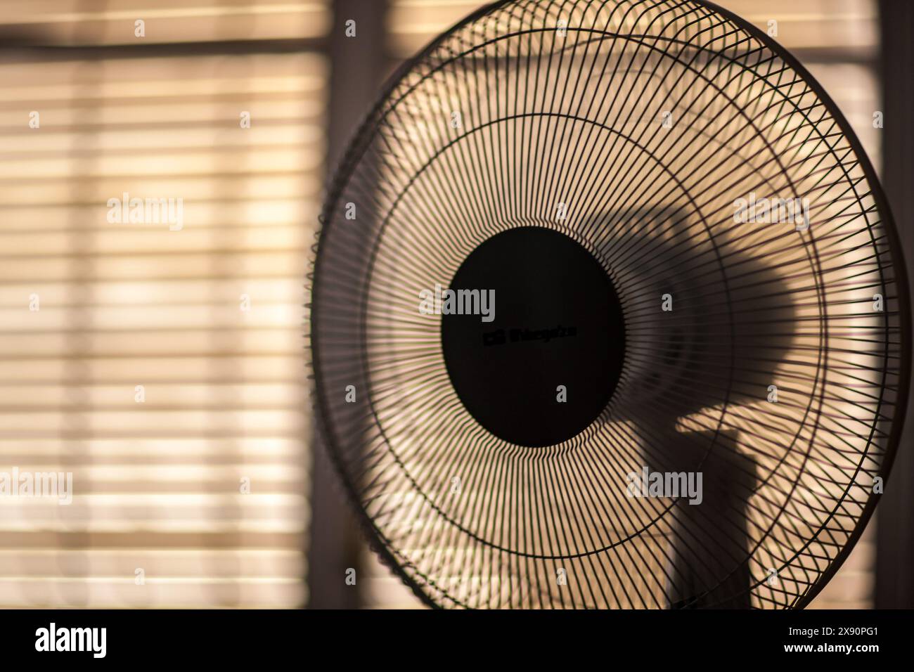 Ein elektrischer Ventilator läuft in einem Raum mit heruntergeklappten Jalousien an einem heißen Sommertag in Sevilla, Spanien. Stockfoto