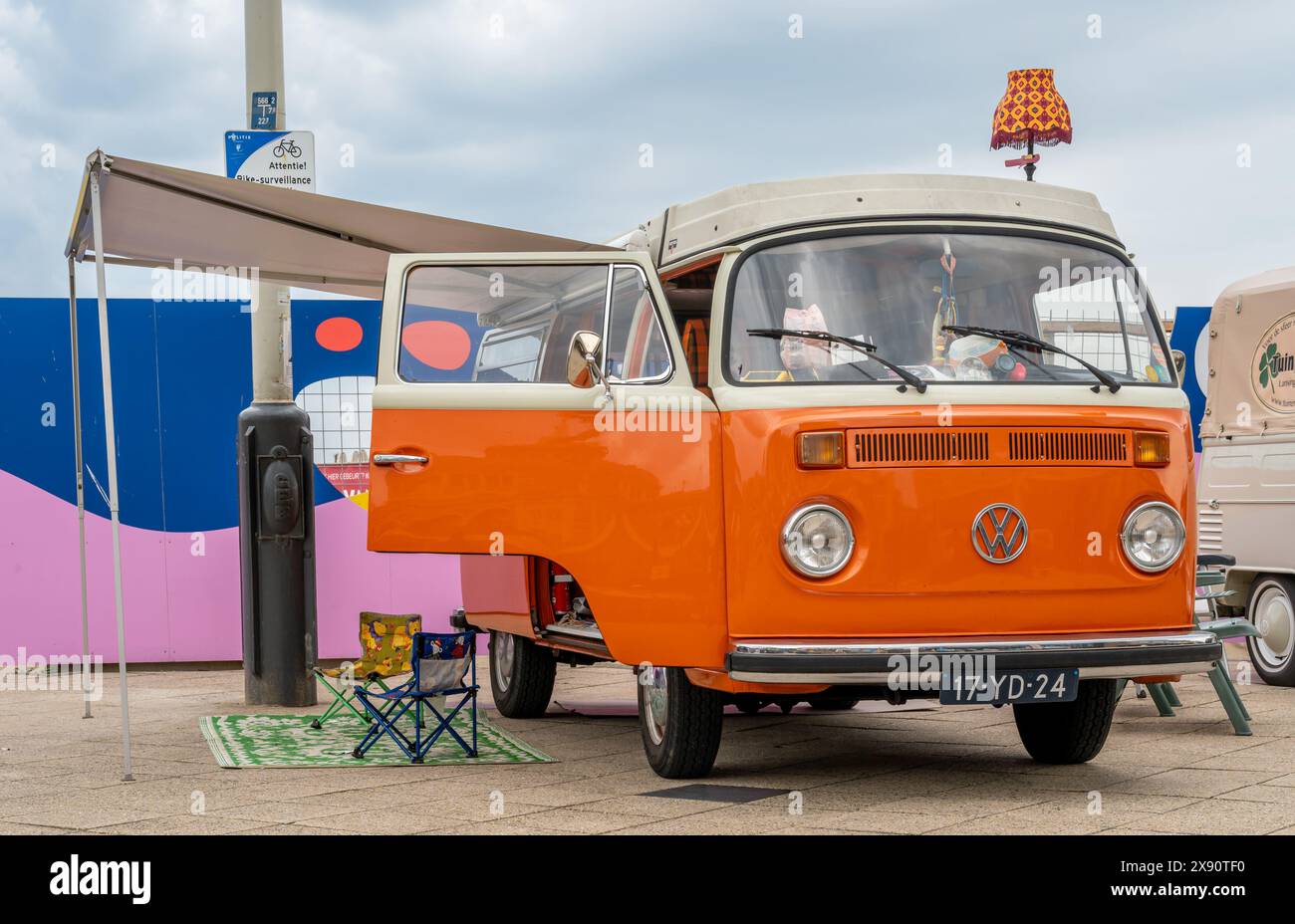 Scheveningen, Niederlande, 26.05.2024, Retro Volkswagen Wohnmobil von 1975 in orangefarbener Farbe mit Seitenzelt auf der Aircooler Oldtimer-Messe Stockfoto