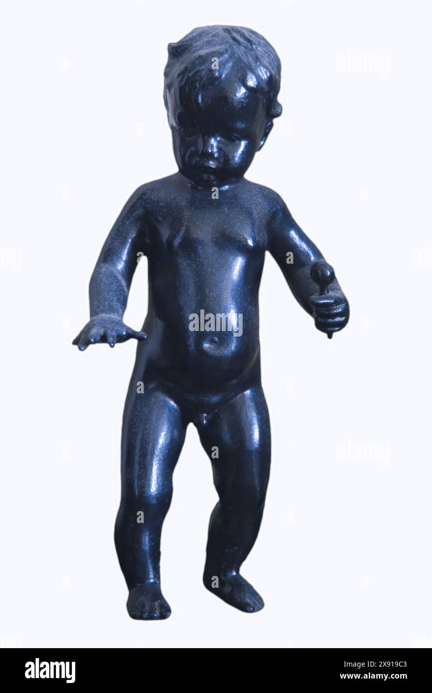 Gusseiserne Figur eines Jungen mit einem Rasselisolat auf weißem Hintergrund Nahaufnahme. Stockfoto