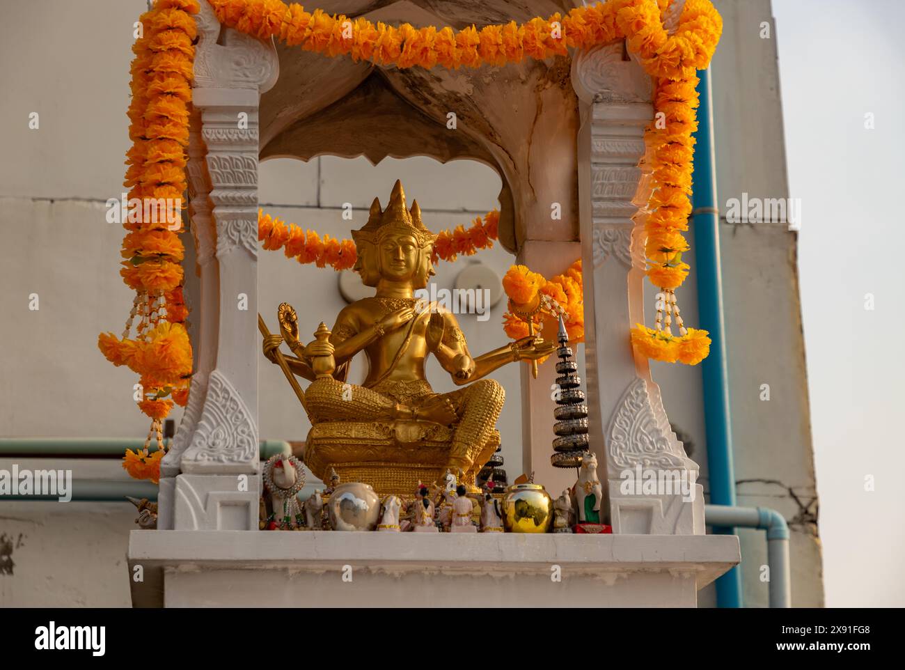 Ein Bild eines goldenen Buddha-Schreins mit vier Gesichtern auf einem Gebäude. Stockfoto