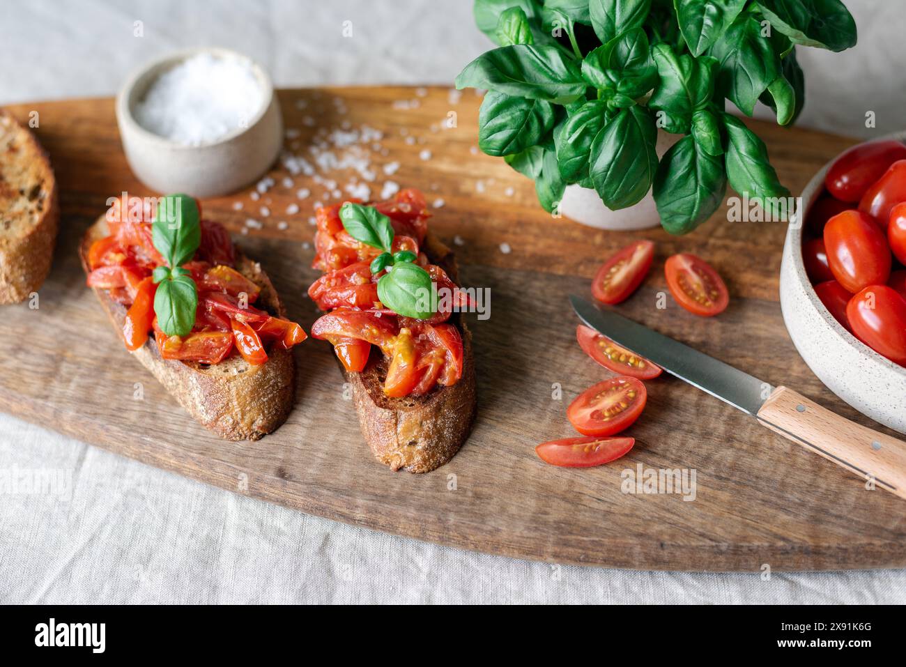 Klassische Bruschetta mit Tomaten auf einem Holzschneidebrett. Stockfoto