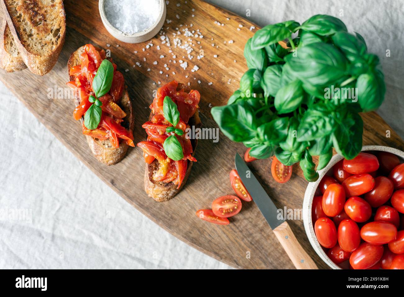 Klassische Bruschetta mit Tomaten auf einem Holzschneidebrett. Stockfoto