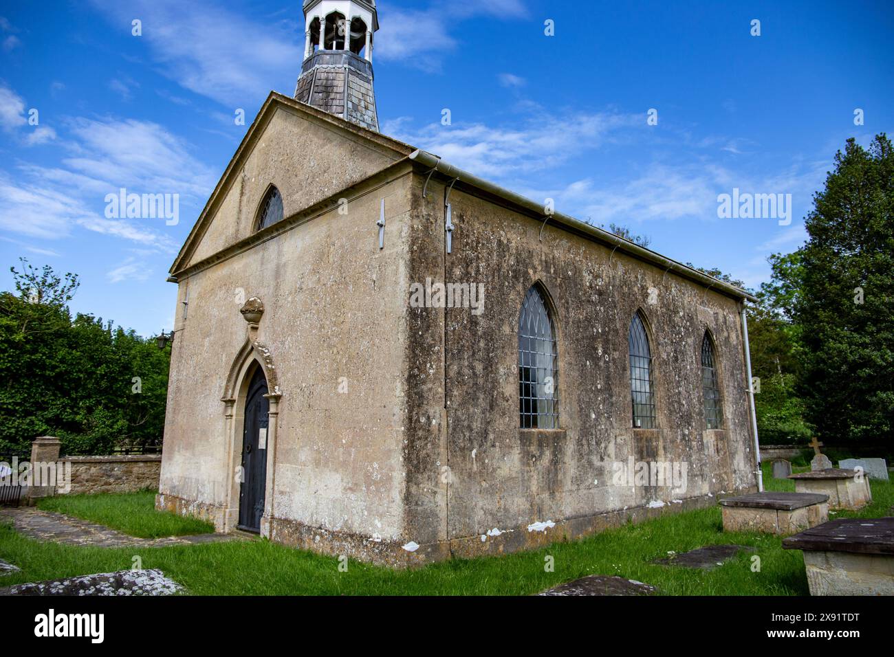 St Giles Kirche Tytherton Kellaways Wiltshire mit einem Glockenturm umgeben von einem Friedhof unter einem blauen Himmel mit Wolken Stockfoto