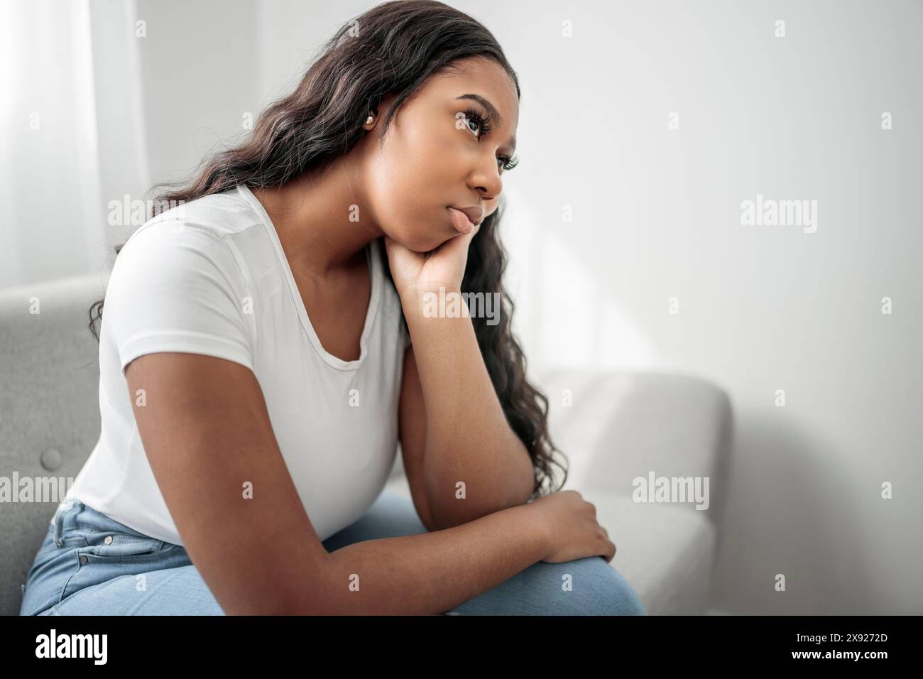 Gestresste miserable schwarze Frau leiden unter Trauer Problem, depressive einsam verärgert afrikanisches Mädchen weinen allein auf dem Sofa Stockfoto