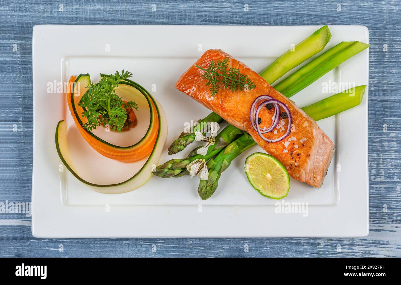 Minimalistische Präsentation eines Tellers mit Lachs und Gemüse - von oben Blick auf Lachs und gedämpftes Gemüse. 016449 042 Stockfoto