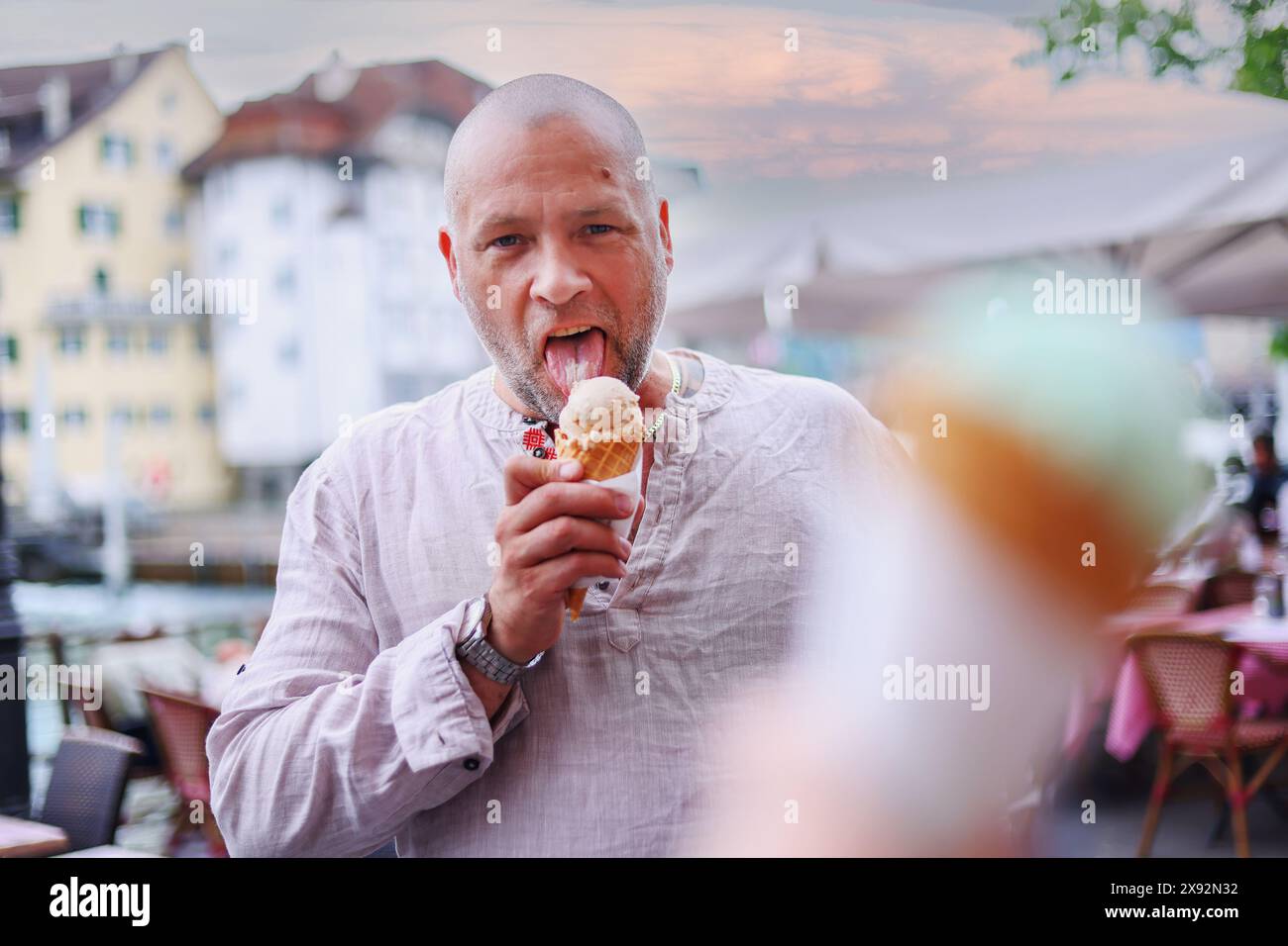 Europäischer Tourist isst Eis, der draußen auf der Straße steht Stockfoto