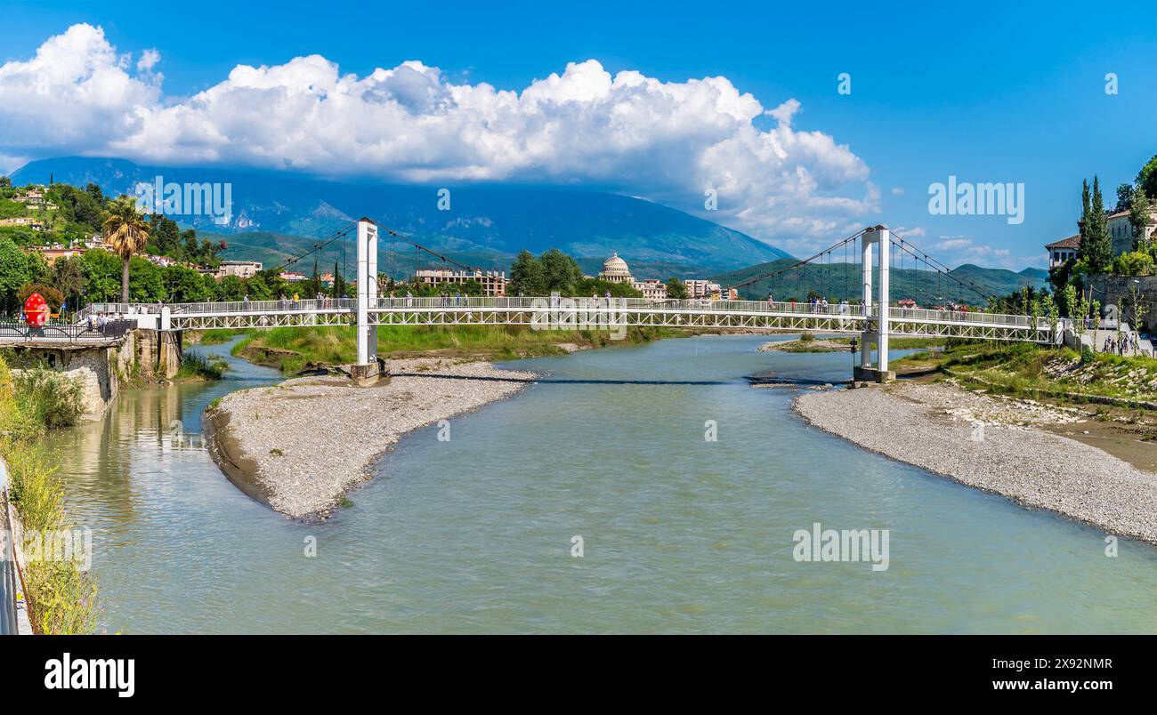 Blick auf den Fluss Osum in Richtung einer Fußgängerbrücke in der Altstadt von Berat, Albanien im Sommer Stockfoto