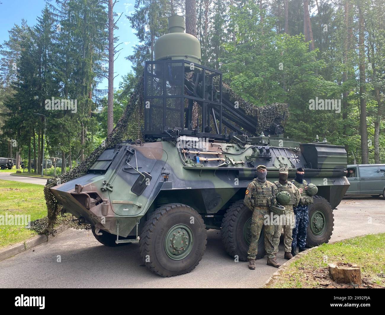 Nemecine, Litauen. Mai 2024. Ein deutscher und zwei litauische Soldaten stehen vor einem gepanzerten Transportfahrzeug der Bundeswehr Fuchs KWS RMB mit Radarerkennung. Quelle: Alexander Welscher/dpa/Alamy Live News Stockfoto