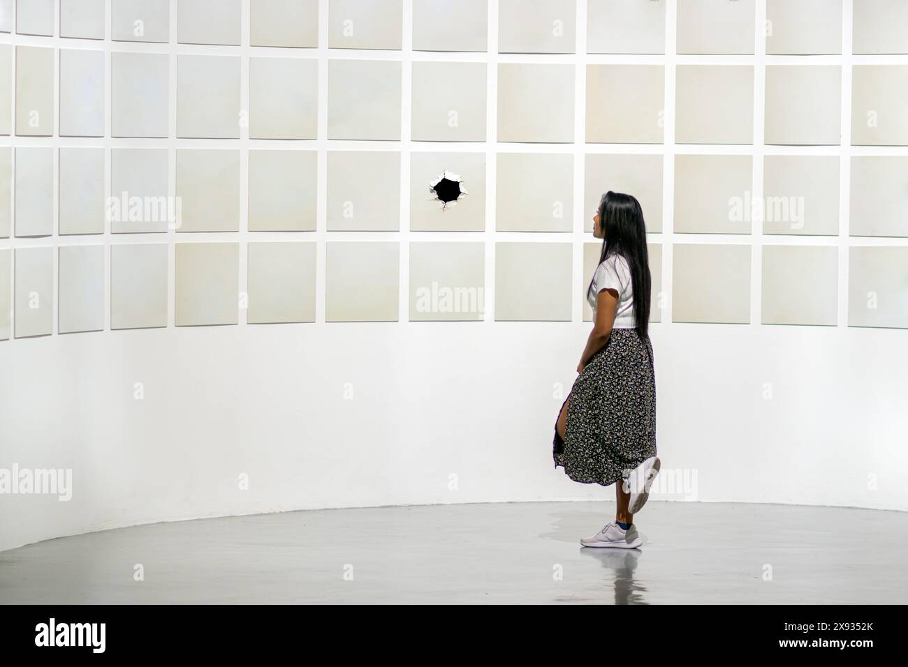 Eine junge Frau schaut sich eine Ausstellung moderner Kunst an Stockfoto