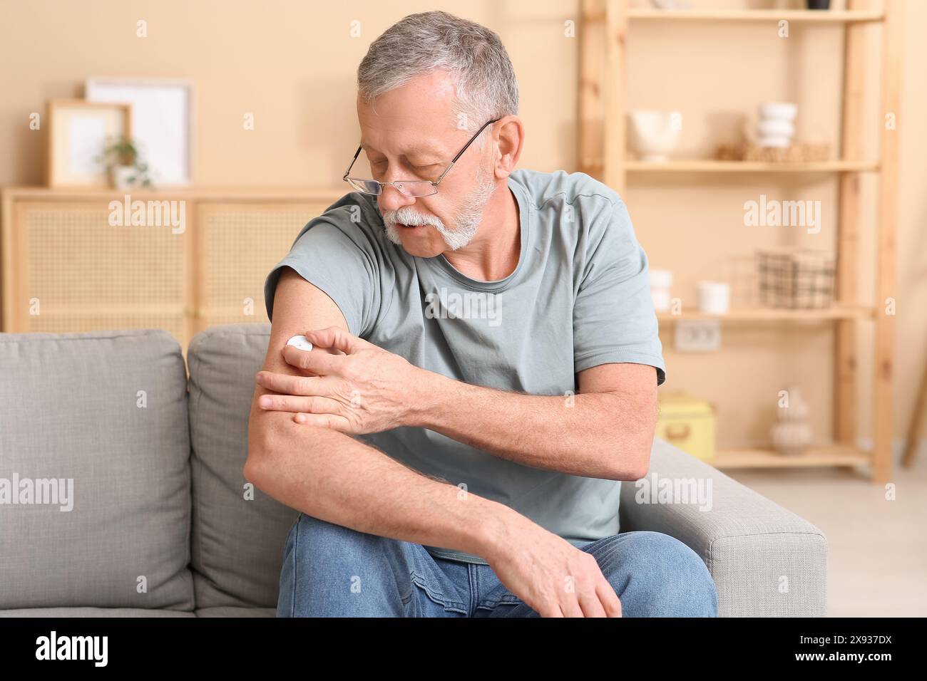 Seniorin mit Glukosesensor zur Messung des Blutzuckerspiegels zu Hause. Diabeteskonzept Stockfoto